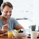 Shot of a man eating breakfast at the dining table